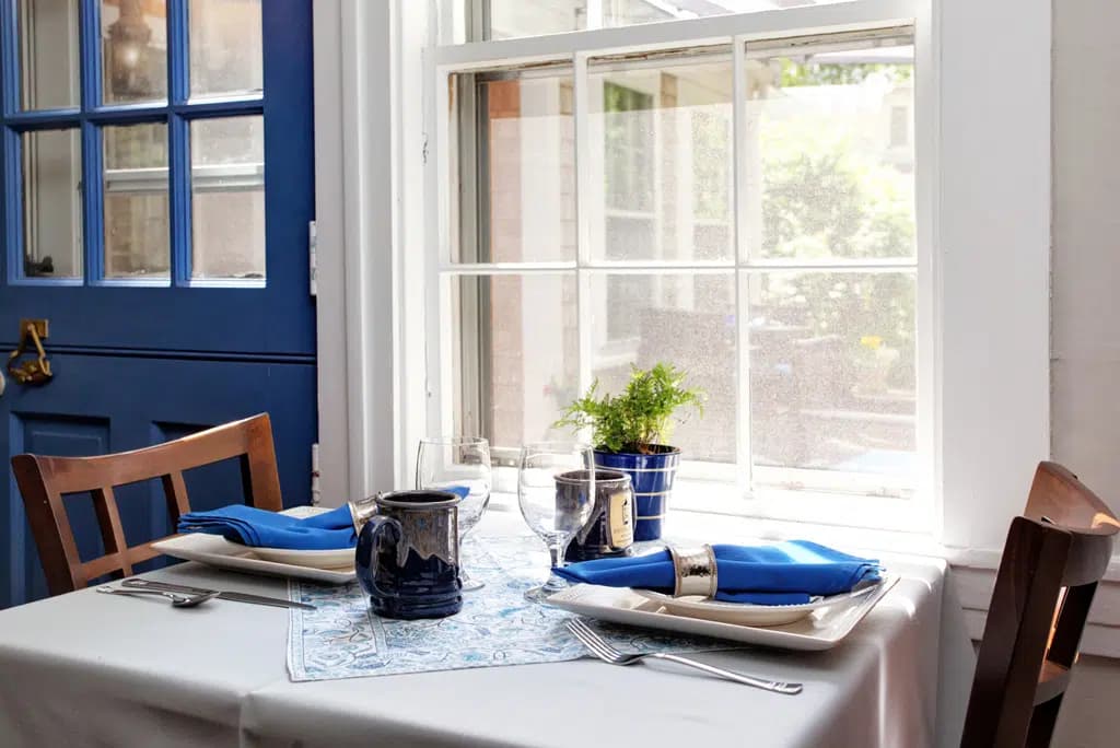 Breakfast Table for two set with white table cloth and blue linens and custom Inn Mug