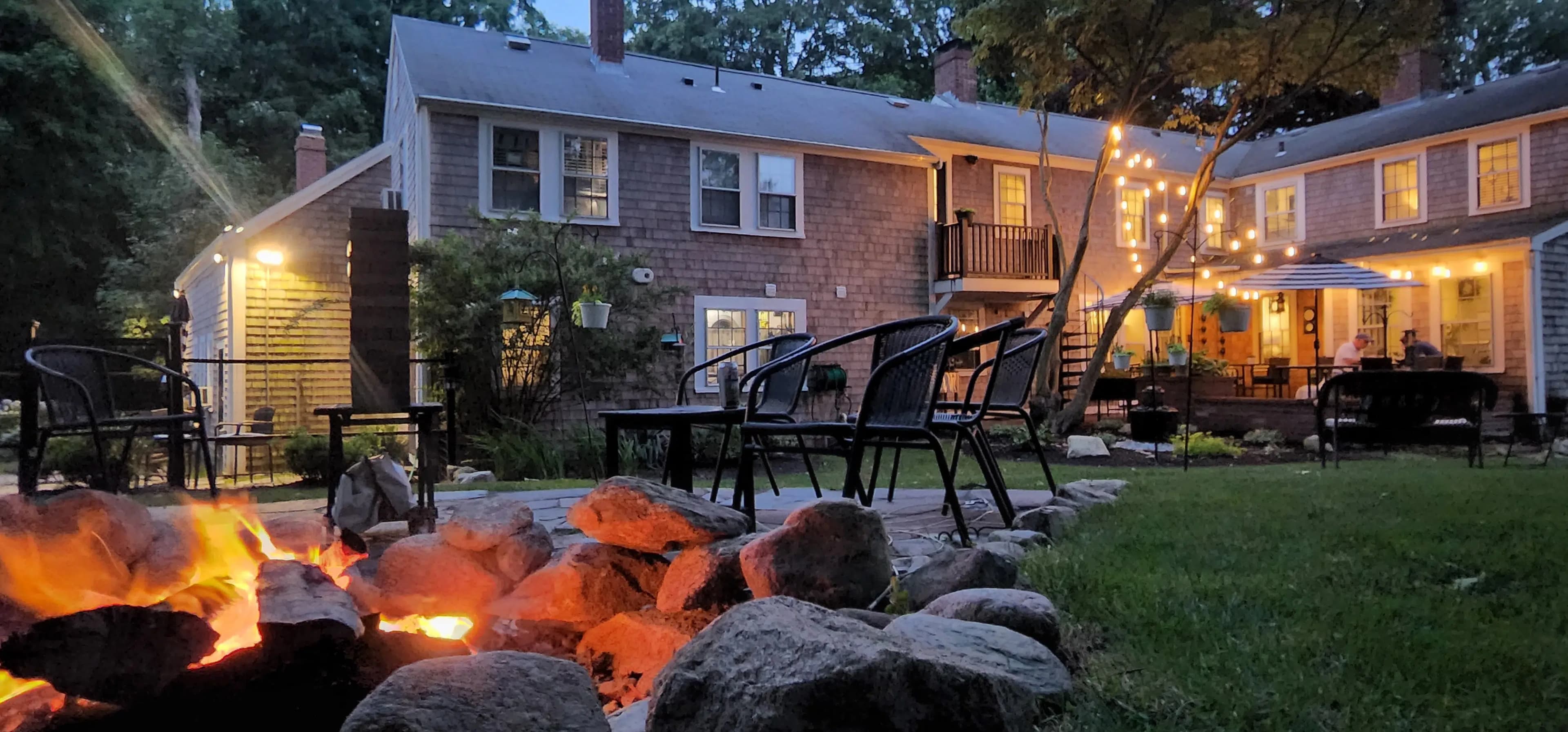 Night view of back of house with patio and fire pit burning