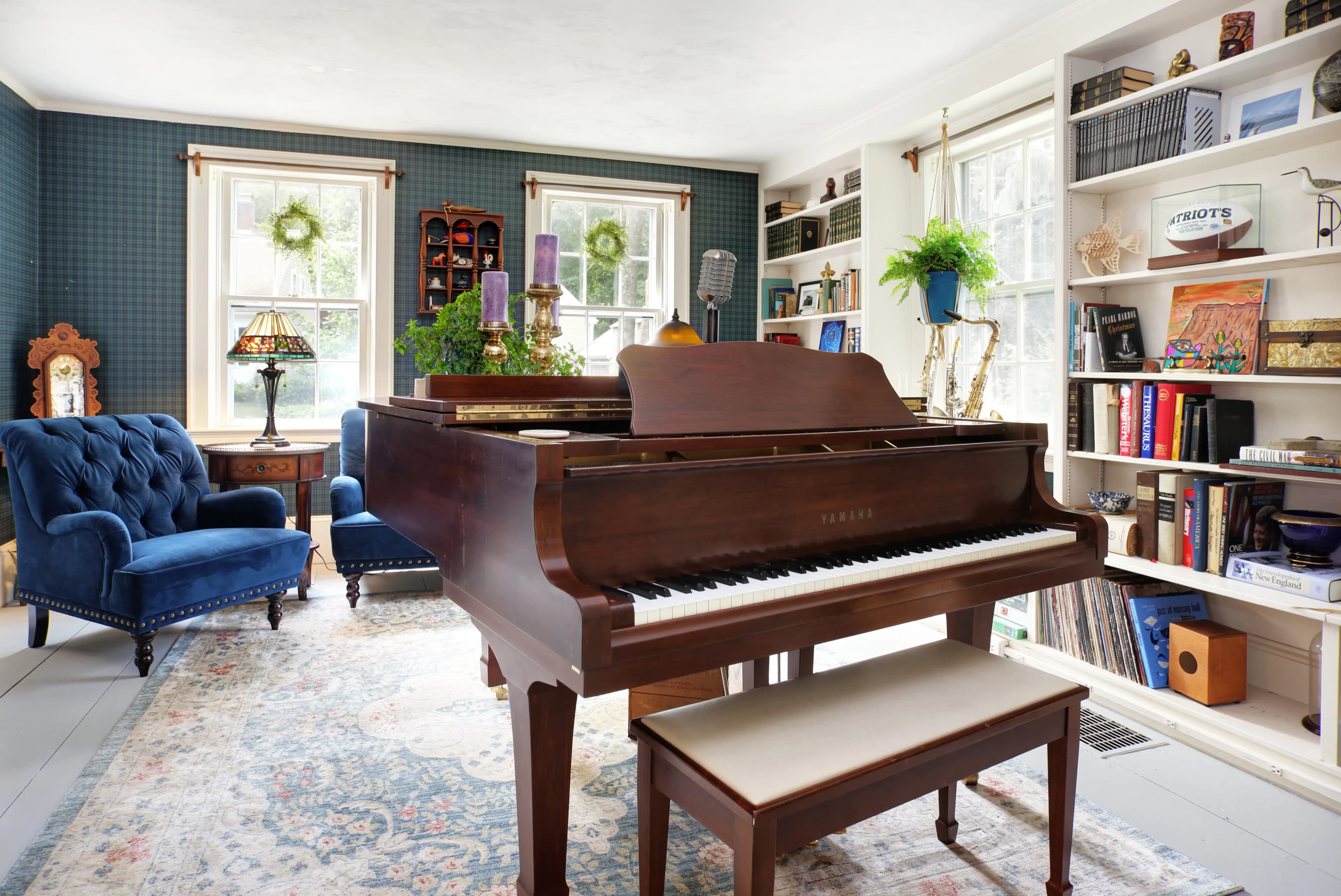 Brown yamaha grand piano in formal room with velour blue chairs