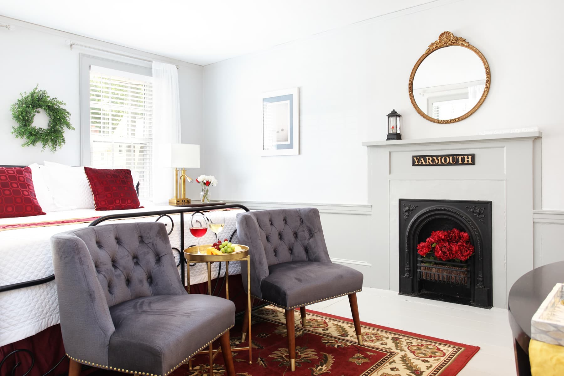 View of sitting area with two gray upholstered chairs on oriental area rug, decorative fireplace on far wall