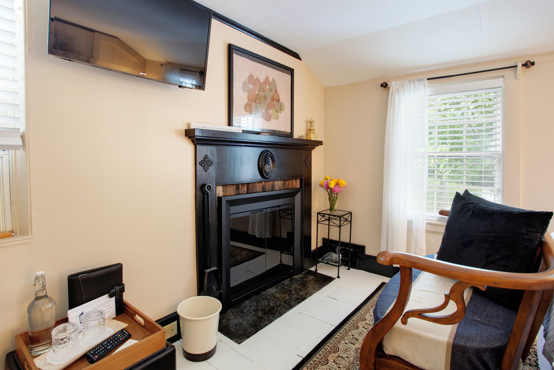 Wooden chair with cushions facing fireplace and wall-mounted flat-screen TV