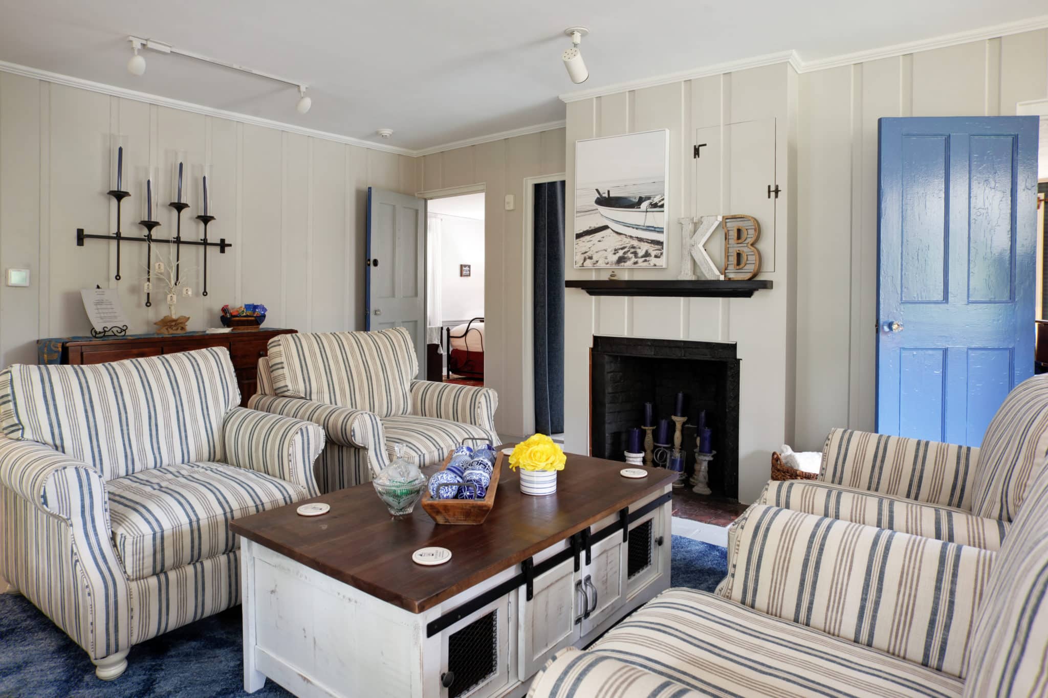 Blue and white striped chairs and white and pine coffee table in living room.