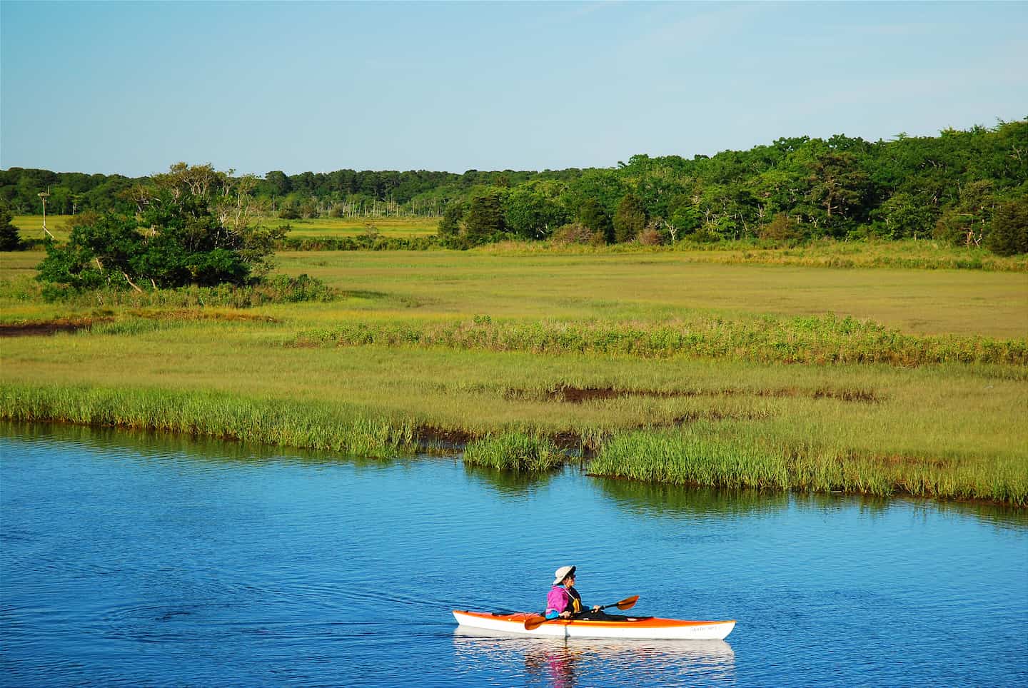 A kayaker paddling on a creek in Cape Cod