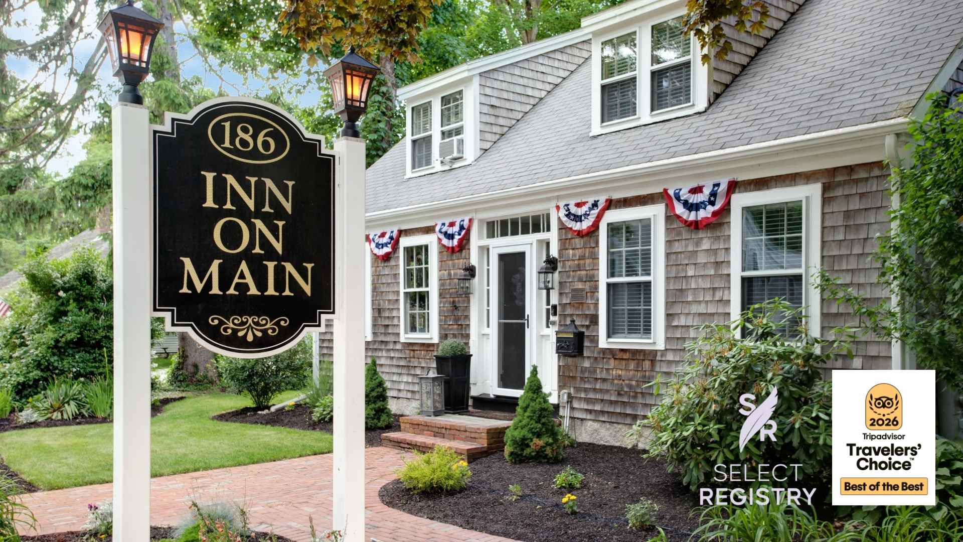 A charming inn with a decorative sign reading "Inn on Main" and patriotic bunting adorning the front.