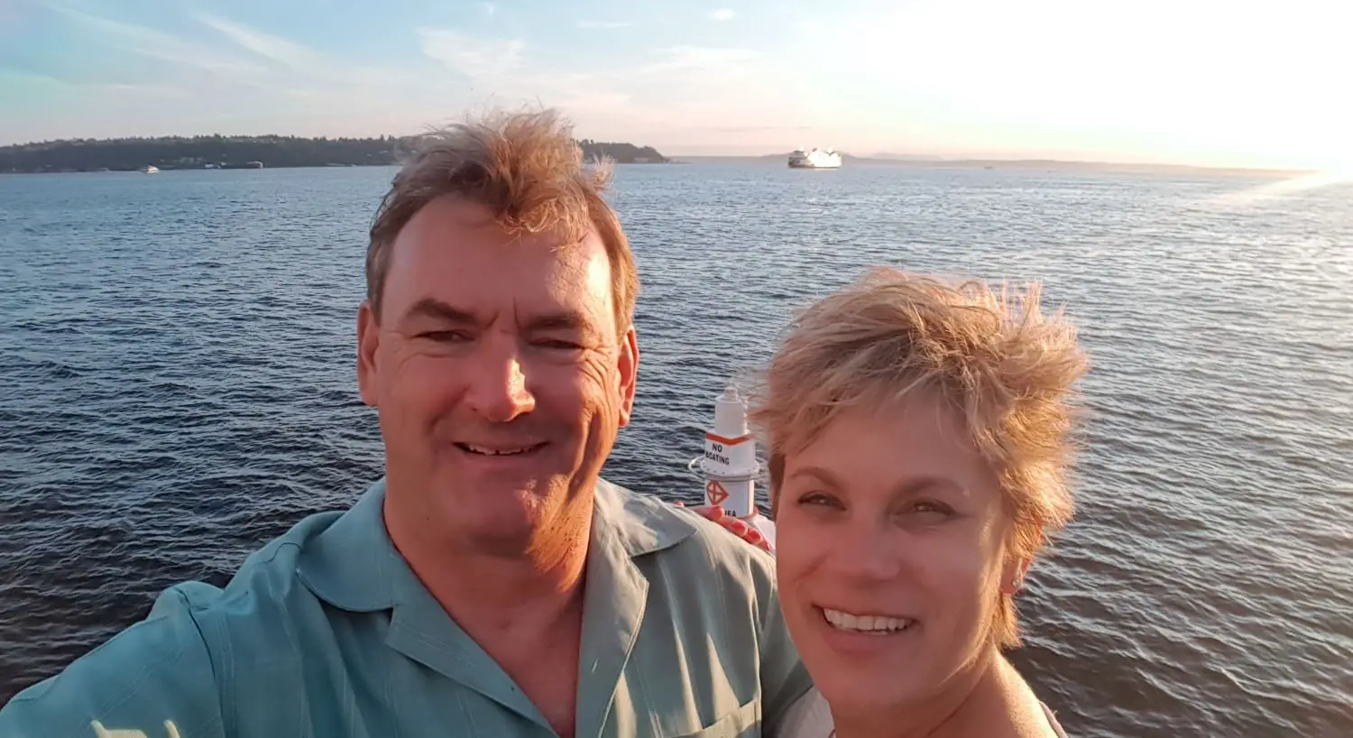 Innkeepers Chris and Sarah standing near water with buoy in floating in the water