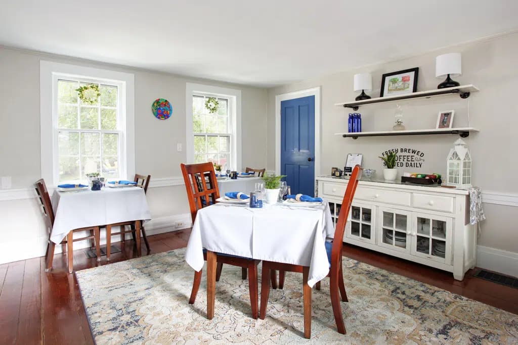 Breakfast Tables in breakfast room with white table clothes and blue linens
