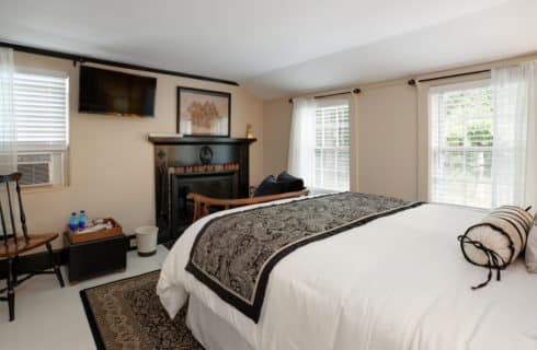 Orleans guest room viewing queen bed, fireplace, seating area